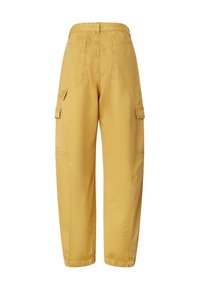 Žute cargo hlače od pamuka, s dva bočna džepa, opuštenog kroja, i vidljivim šavovima na stražnjem dijelu i nogavicama.