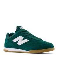 Zapatillas de ante verde con un logo "N" blanco, cordones texturizados y una suela de goma. Cuenta con un diseño de perfil bajo y un cuello acolchado.