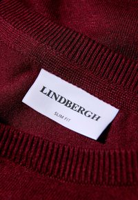 Bordowy sweter z dzianiny o dopasowanym kroju. Zawiera białą metkę z napisem "LINDBERGH" i "SLIM FIT" w czarnym kolorze. Teksturowana tkanina.