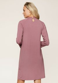 Vadelmanpinkki pitkähihainen mekko, jossa on pyöreä pääntie, jossa on pitsikoristelu, ja pieni avaus takana. Sujuva, kevyt kangas.