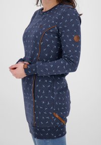 Vestido de suéter azul marino con estampado de pájaros, acentos en azul claro, detalles en cuero marrón, mangas largas y forma ajustada.