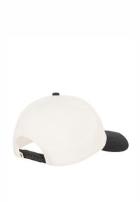 Casquette en coton blanche et noire avec une visière courbée ; bandeau ajustable à l'arrière ; texture lisse ; sans motifs ni logos visibles.