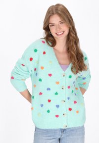 Ljus teal-färgad cardigan med flerfärgade hjärtformade mönster, V-ringning och knäppning, tillverkad av ett mjukt, texturerat tyg.