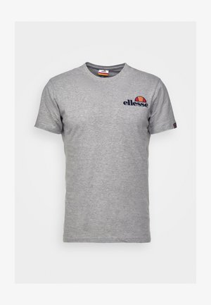 Camiseta de algodón gris con mangas cortas. Presenta un logo oscuro de "ellesse" en el lado izquierdo del pecho y un detalle de logo colorido en el cuello.