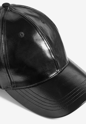 Melna cepure, izgatavota no spīdīga sintētiska materiāla, ar izliekto malu, sešpanelu dizainu un redzamām šuvēm uz kronīša.