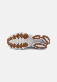 Sole di scarpa atletica bianca con motivo di trazione in gomma marrone e nervature sagomate. Presenta ritagli geometrici per flessibilità e aderenza.