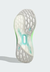 Schuhsohle mit einer weißen strukturierten Oberfläche und grünen Akzenten, halbtransparenten Bereichen und einem markanten Torsion System-Logodetail.
