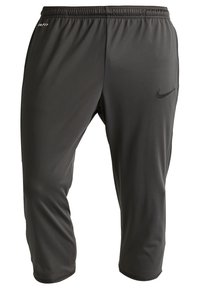 Pantalones deportivos Nike en gris oscuro, fabricados con material ligero, presentan una cinturilla elástica y un pequeño logo en el lado izquierdo.