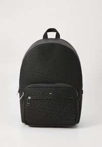 Zwarte rugzak gemaakt van gestructureerd materiaal, met een groot afgerond lichaam en een voorvak met ritssluiting met zilverkleurige details en logomerk.