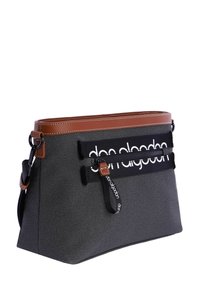 Bolsa textil negra con acentos de cuero marrón, bolsillo con cremallera y detalle de logo en la parte frontal. Forma rectangular, superficie texturizada.