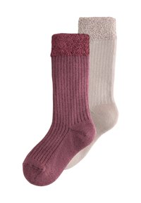 Par ribbede crew-sokker med foldede fuzzy manchetter i mauve og lys beige farver, der overlapper på en hvid baggrund.