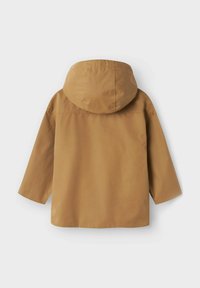 Tan huva jacka med en slät yta, långa ärmar och en avslappnad passform. Har en sömdetalj på baksidan, inga synliga knäppningar.