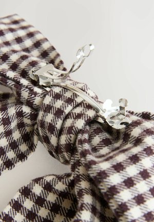 Ruskea ja kerma ruutukuvioinen kangas hiusklipsi, jossa on metallinen solki, ja se on varustettu sileällä pinnalla ja kieputetulla muotoilulla.