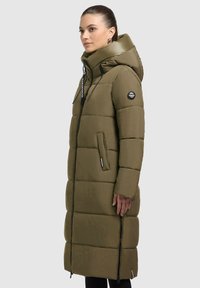 Olijfgroen pufferjas met een capuchon, voorzien van doorgestikte secties, een ritssluiting aan de voorkant, zijzakken en een logoapplicatie op de mouw.