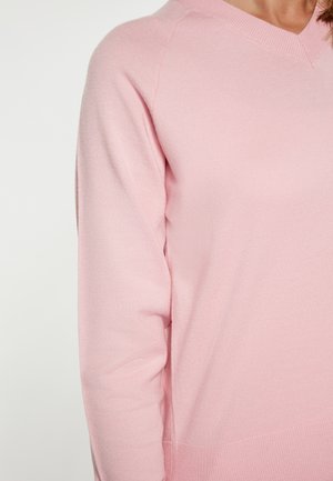 Lyserød striktrøje med V-hals, der har lange ærmer og en blød tekstur. Ribbet detaljer ved kanten og ærmerne, tætsiddende design.