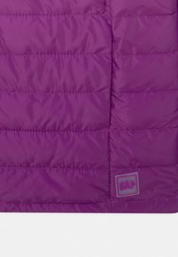 Fioletowa pikowana kamizelka puchowa z połyskującym wykończeniem. Posiada małą, kwadratową łatkę z logo GAP w dolnym rogu.