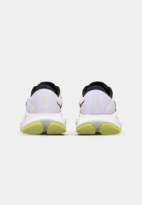 Lightweight running shoes with a white mesh upper, pink accents, and a black heel. Features a yellow sole with a textured grip pattern.
