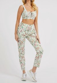 Top court à imprimé floral et pantalon assorti en tissu vert clair. Le top présente un détail à lacets ; le pantalon a une taille élastique. Baskets incluses.