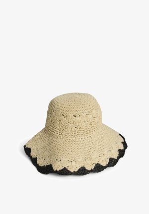 Chapeau de soleil beige en crochet avec des bords festonnés, orné d'un liseré noir autour du large bord.