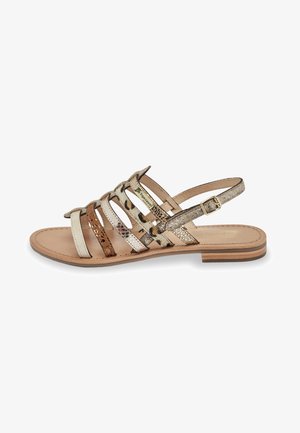 Sandalo flat con cinturini, caratterizzato da dettagli in oro metallico, bronzo e stampa animalier, con una soletta in pelle e un sottile cinturino alla caviglia regolabile.