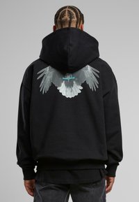 Sort hætte sweatshirt lavet af bomuld, med et stort grafisk tryk af grå vinger på ryggen. Løs pasform med ribbede manchetter.