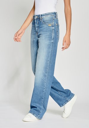 Light blue wide-leg jeans with a faded finish, featuring a button closure, five pockets, and frayed hem, paired with white sneakers.