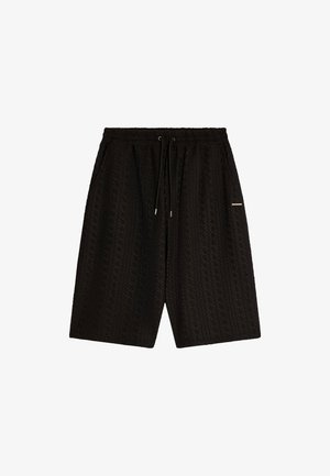 Black patterned shorts with an elastic waistband, drawstring closure, and two side pockets; textured fabric with geometric detailing.