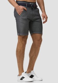 Shorts en denim gris au design ajusté, avec des revers, des poches avant et une ceinture tissée bleu marine avec un accent marron.