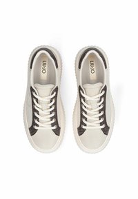 Baskets en mesh beige avec des accents brun foncé, bout rond, lacets blancs et semelles en caoutchouc texturées. Logo visible sur la semelle intérieure.