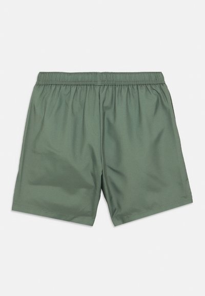 Πράσινο, ελαφρύ σορτς με ελαστική μέση. Λείος υφής, μήκος μέχρι το γόνατο, χωρίς εμφανείς τσέπες ή άλλα στοιχεία.