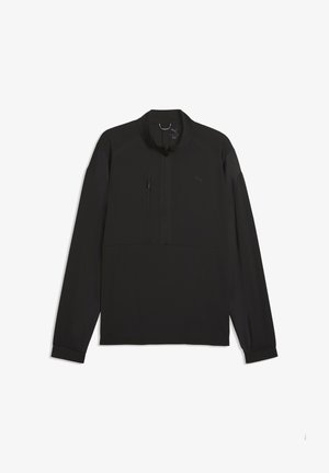 Mustasta kevyestä kankaasta valmistettu takki, jossa on neljänneksen mittainen vetoketju, rintatasku ja joustavat hihansuut. Minimalistinen muotoilu ilman näkyviä kuvioita.