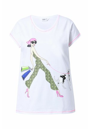 T-shirt blanche arborant un design imprimé d'une silhouette en combinaison léopard avec des accents roses, tenant des sacs de shopping et promenant un chien.