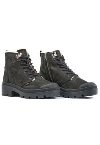 Botines de cuero negro con un acabado texturizado, cuello acolchado, puntera redonda, cordones en la parte delantera, cremallera lateral y suela de goma robusta.