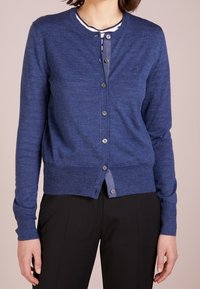 Marinblå cardigan i mjukt material, med rund hals, knappstängning framtill och ribbad mudd och nederkant.