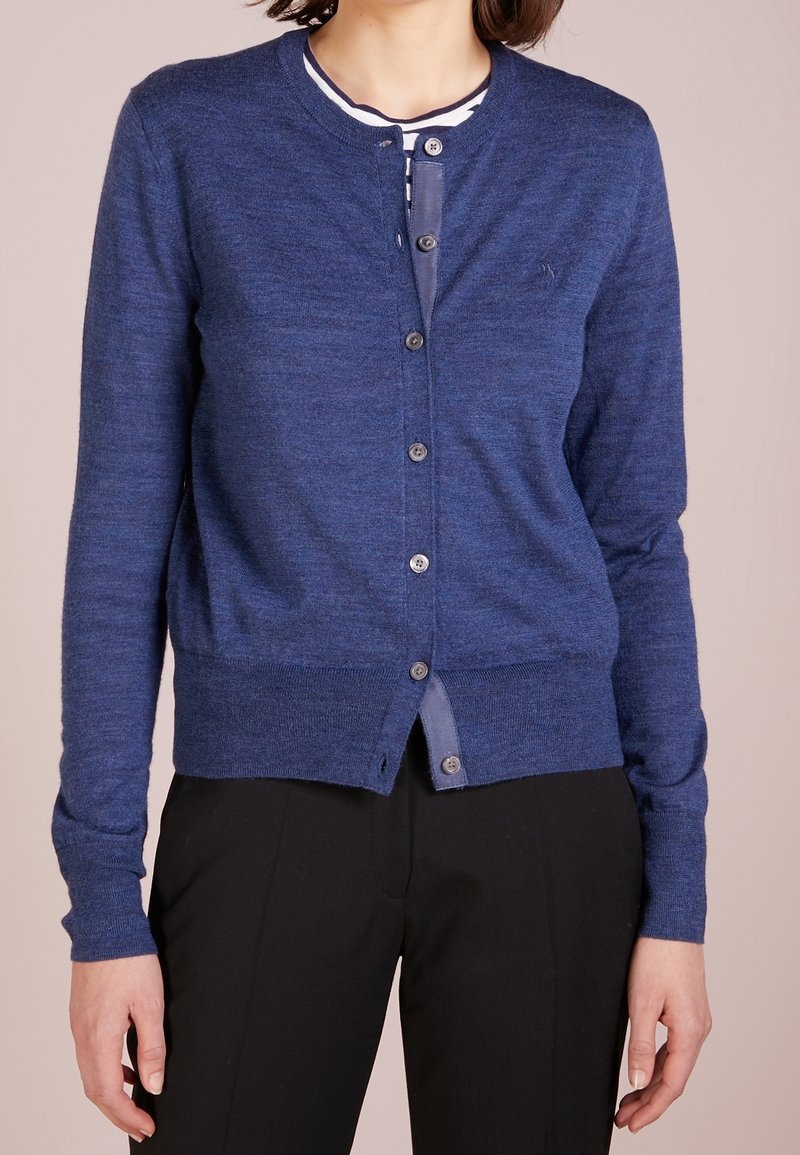 Marinblå cardigan i mjukt material, med rund hals, knappstängning framtill och ribbad mudd och nederkant.