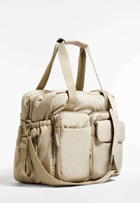 Borsa imbottita beige con doppi manici superiori, tracolla removibile, molteplici tasche con zip e lato elastico per l'espansione. Tessuto intrecciato.