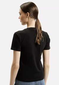 Czarny t-shirt z krótkim rękawem i okrągłym dekoltem. Miękka tkanina, dopasowany krój i minimalistyczny styl. Widok z tyłu pokazuje gładką strukturę i czyste linie.