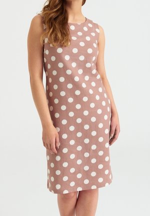 Une robe sans manches en tissu rose pâle ornée de grands pois blancs, avec une silhouette droite et un ourlet arrivant au genou.