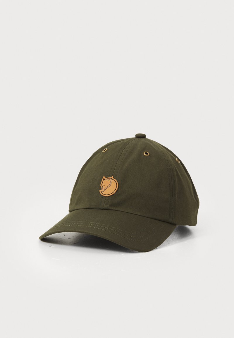 Donkergroene baseballpet met een bruine voslogo-patch op de voorkant, kleine ventilatiegaatjes en een gebogen rand op een witte achtergrond.