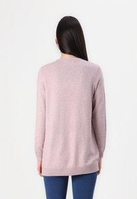 Maglione a maglia rosa chiaro con maniche lunghe, scollatura rotonda e orlo a costine; texture liscia e vestibilità comoda.
