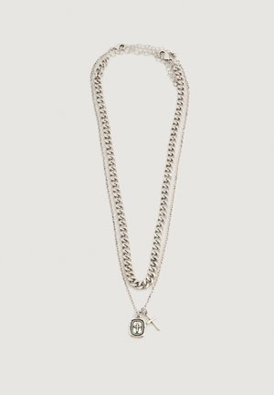 Δύο ασημένια κολιέ, ένα χοντρό και ένα λεπτό, με μενταγιόν που περιέχουν ένα σταυρό και έναν σταυρό σε κλειστό σχέδιο.