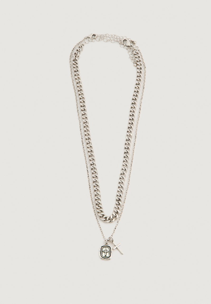 Kaks hõbedast kettkaelakeed, üks paks ja teine õhuke, risti ja suletud ristiga disainitud ripatsitega.