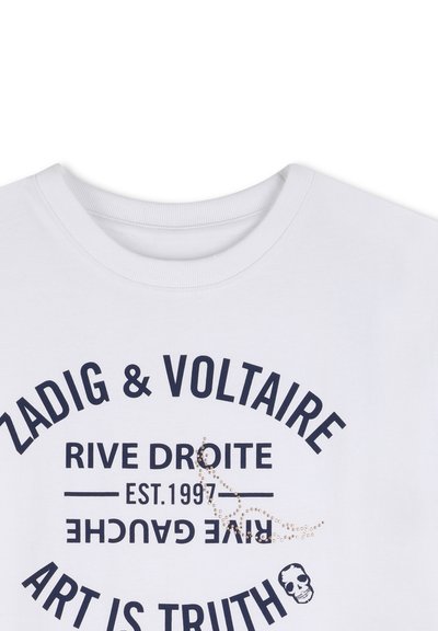 Fehér kereknyakú póló fekete feliratokkal: "Zadig & Voltaire", "Rive Droite", "Est. 1997", "Rive Gauche" fejjel lefelé, és "Art is Truth" koponya ikonnal.