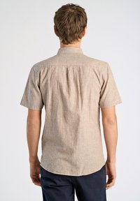 Kortärmad skjorta i ljusbeige med tunna vita lodräta ränder; har en rak fåll och bakfickor för enkel rörelse.