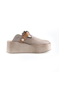 Chaussure à plateforme en daim beige avec semelle épaisse et bride réglable marron munie d'un bouton-pression métallique.