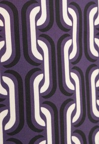 Tessuto con un motivo geometrico ripetitivo di forme curve bianche e nere su uno sfondo viola. Texture liscia, design moderno.