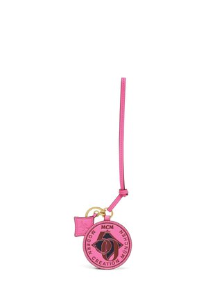 Porte-clés rond en cuir rose avec logo MCM noir, anneaux dorés et une petite étiquette en cuir rose embossée.