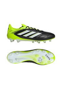 Crampons de football Adidas Copa noirs et vert néon avec des rayures blanches, montrés de côté et de dessous.