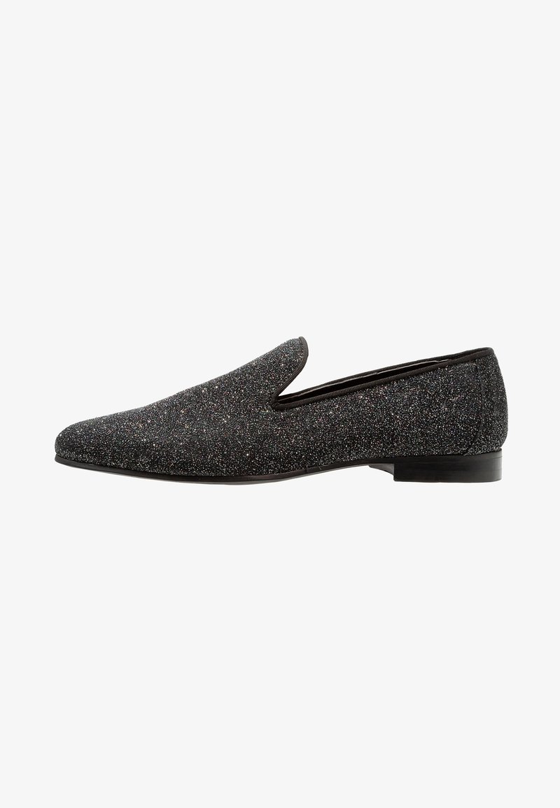 Mocassin noir pailleté à enfiler avec petit talon et bout arrondi, vue de côté sur fond blanc.