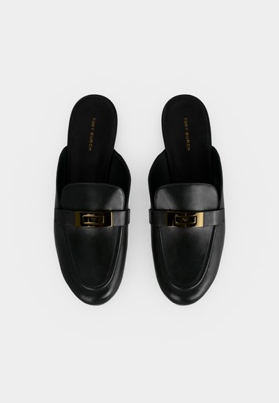 Ζευγάρι μαύρα δερμάτινα loafers χωρίς κορδόνια με χρυσή αγκράφα και λογότυπο Tory Burch στις εσωτερικές σόλες, σε λευκό φόντο.